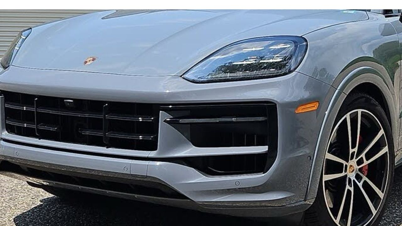 The front end and wheel of a grey Porsche Cayenne.
